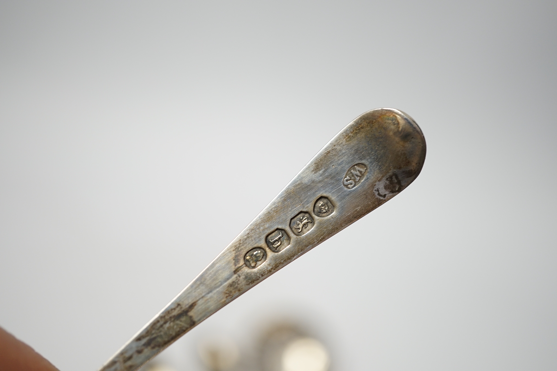 An 18th century silver mote spoon, marks rubbed, 11.8cm and five other various silver spoons and a pair of silver sugar tongs, 5.1oz.